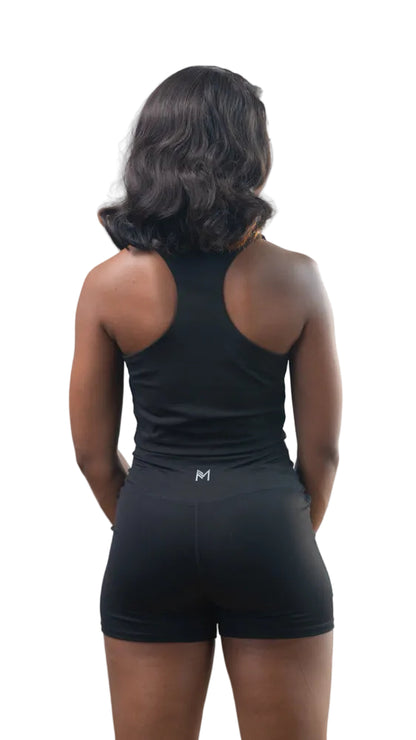 Person wearing a black tank top and shorts on a white background
