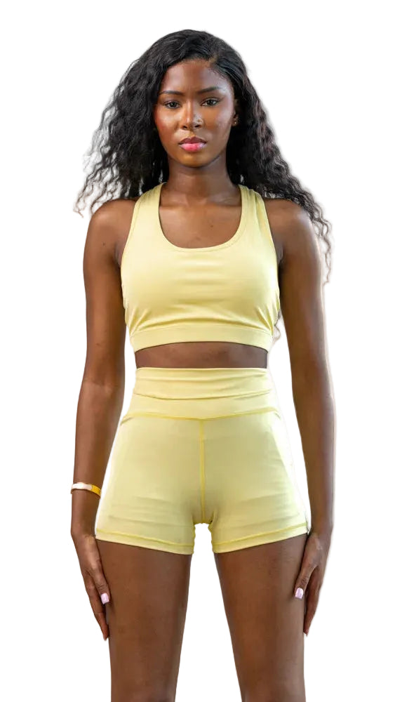 Woman wearing a yellow athletic outfit on a white background