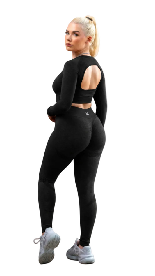 Woman wearing a black athletic outfit on a white background