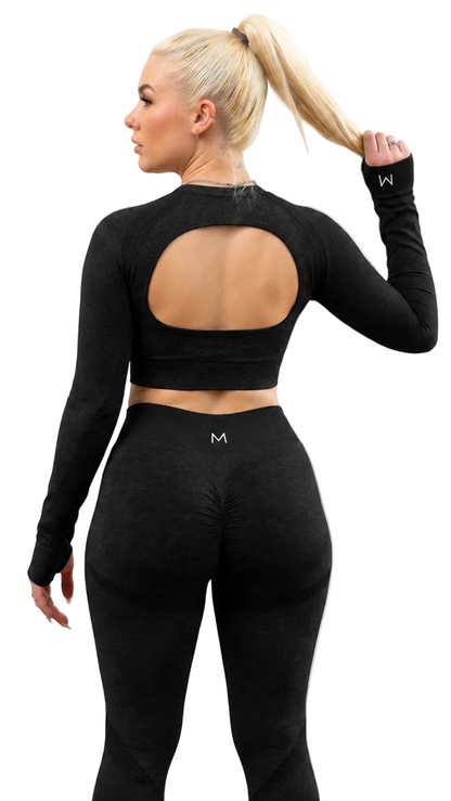 Woman wearing a black long-sleeve crop top and leggings with a logo on a white background