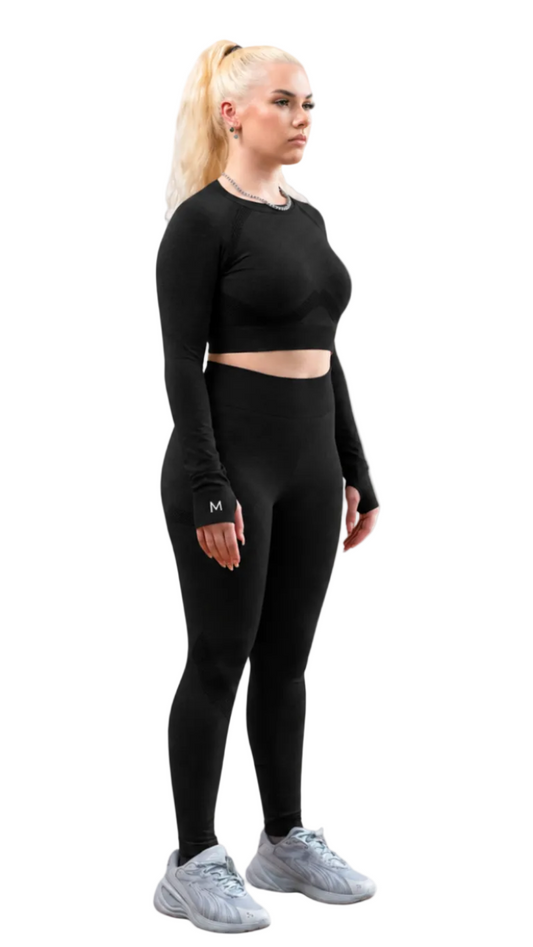 Woman wearing a black athletic outfit on a white background