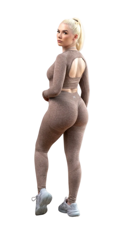 Person wearing a beige long-sleeve top and leggings on a white background