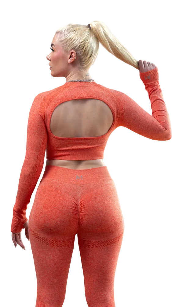 Person wearing an orange athletic outfit with a cut-out design on a white background