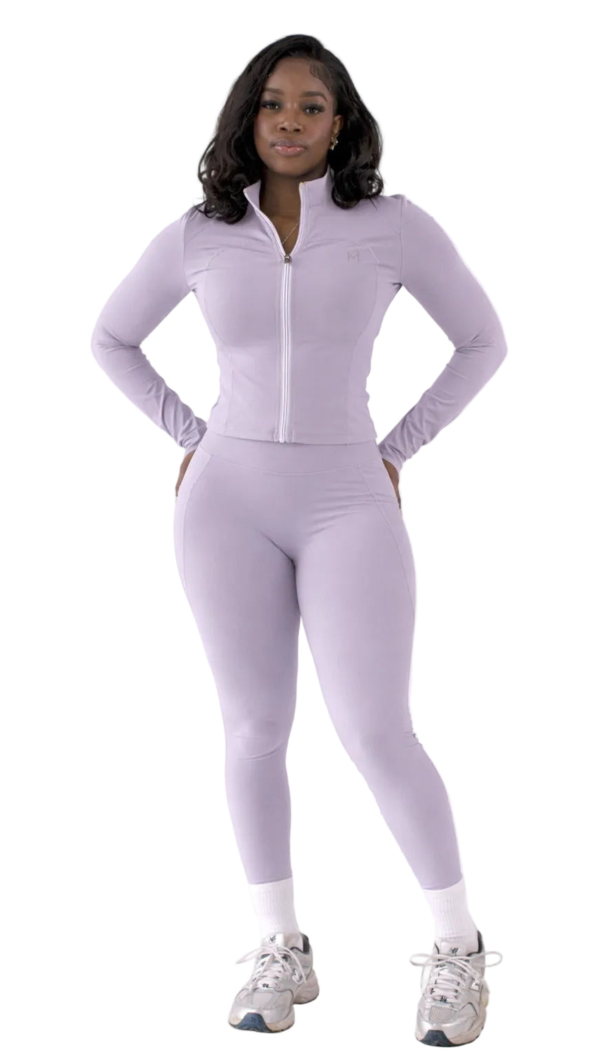 Woman wearing a light purple athletic outfit on a white background