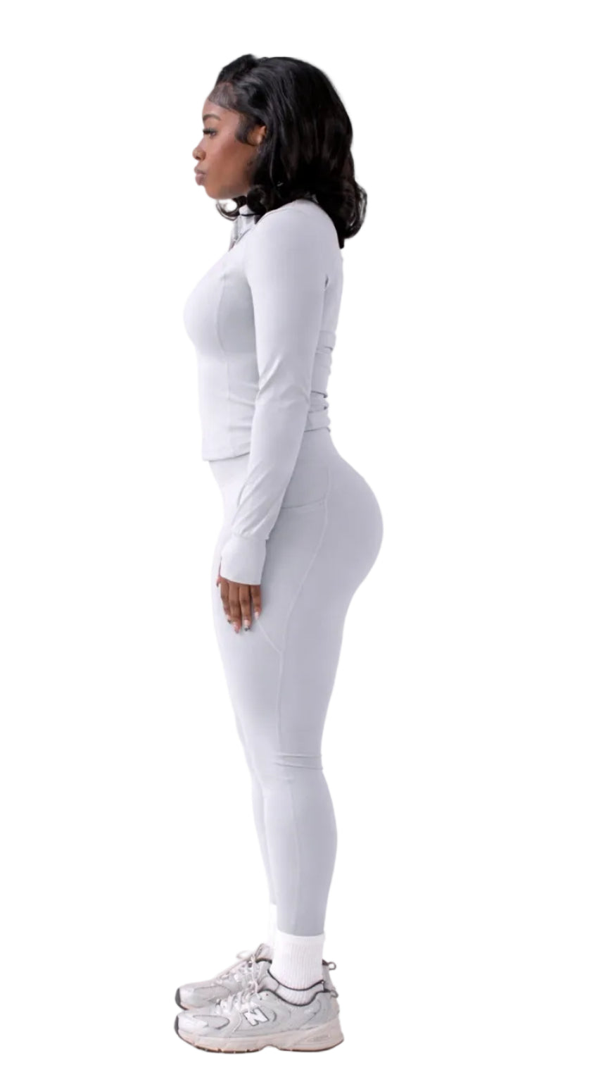 Person wearing a white long-sleeve top and leggings on a white background